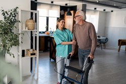 Nurse Aide helping senior citizen walk in LTC facilty