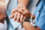 Nurse and patient holding hands